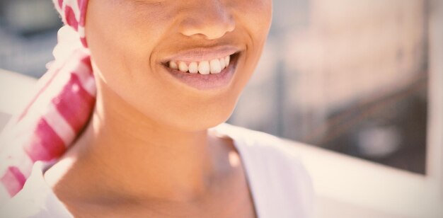 Portrait of smiling woman wearing scarf with breast cancer awareness