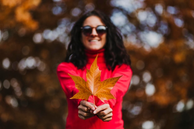 Portrait of smiling woman wearing sunglasses standing outdoors during autumn