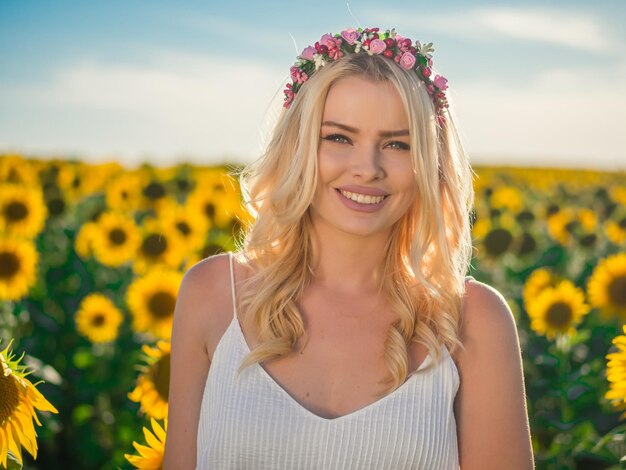 Portrait of smiling woman wearing wreath against sunflower field