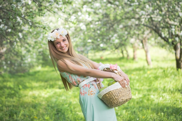 Portrait of smiling woman with basket standing on field