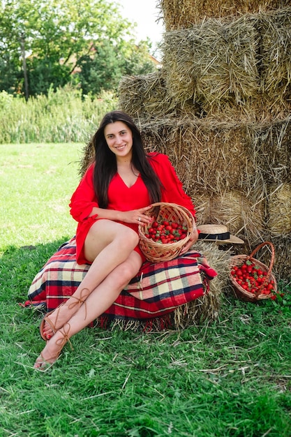 Portrait of smiling woman with basket of strawberries