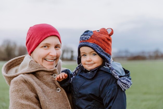 portrait of smiling woman with boy standing at park