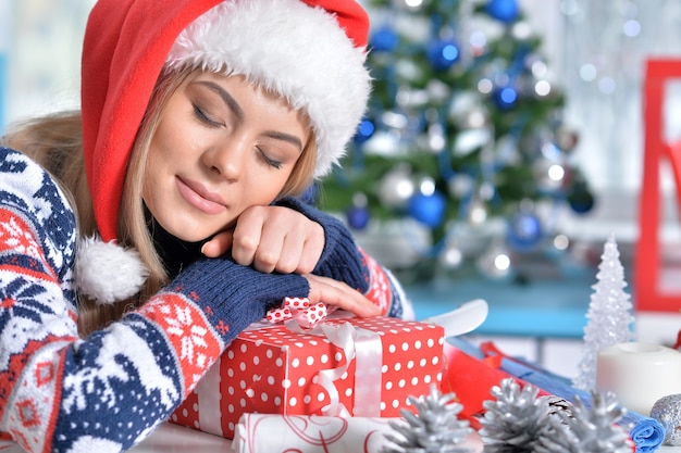 眠っているクリスマスプレゼントと笑顔の女性の肖像画