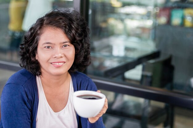 Portrait of smiling woman with coffee cup