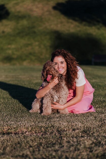 Foto ritratto di una donna sorridente con un cane sul campo