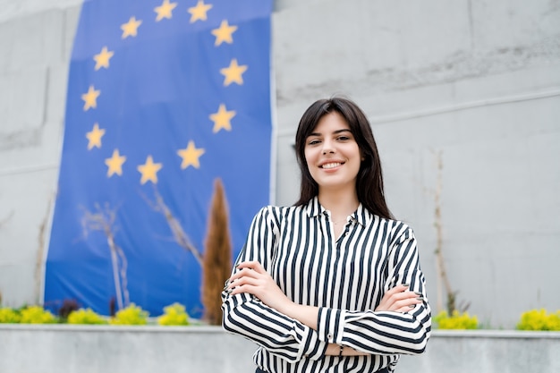 Foto ritratto di una donna sorridente con la bandiera dell'unione europea sul