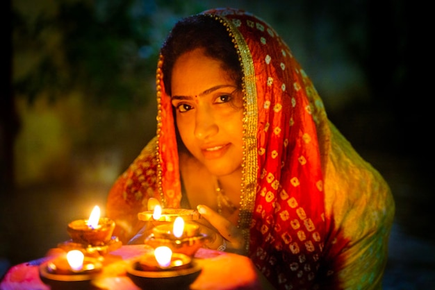 portrait of smiling woman with illuminated oil lamps