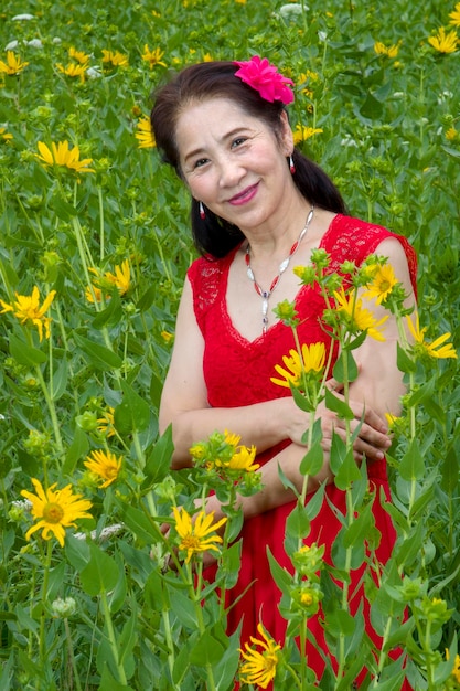 Portrait of smiling woman with red flower