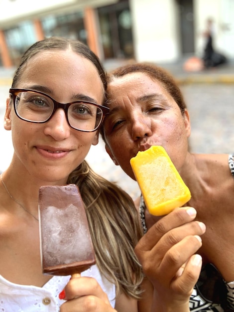 Photo portrait of smiling women with ice cream on street