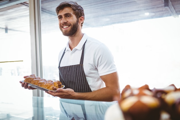  Portrait of smiling worker showing basket of bread