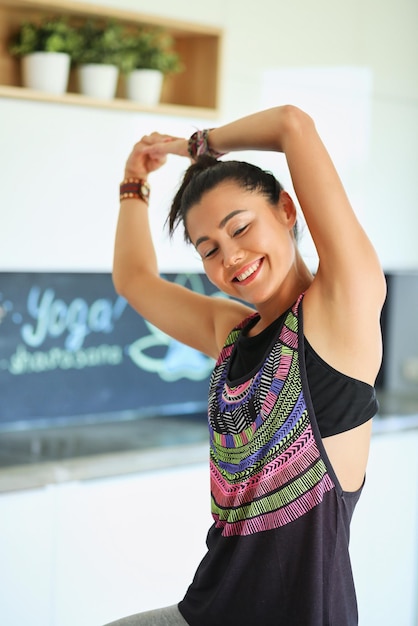 Portrait of smiling yoga woman sitting at yoga mat after workout at yoga studio yoga woman