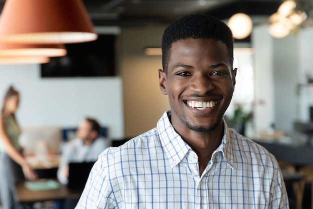 portrait of smiling young african american businessman in creative office
