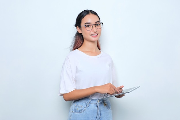 Portrait of smiling young Asian girl in white tshirt using digital tablet isolated on white background