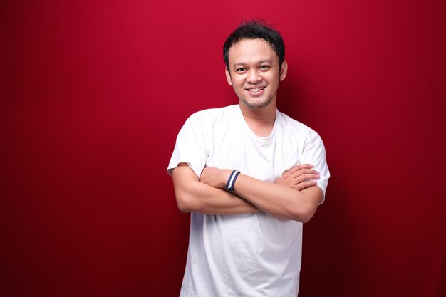 Portrait of smiling young asian man wearing black shirt isolated on red