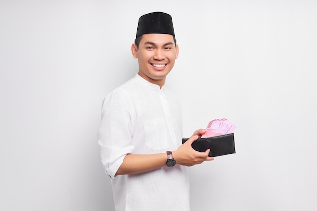 흰색 배경에 고립 된 전체 현금 돈의 지갑을 보여주는 웃는 젊은 아시아 무슬림 남자의 초상화 사람들 종교 이슬람 라이프 스타일 개념