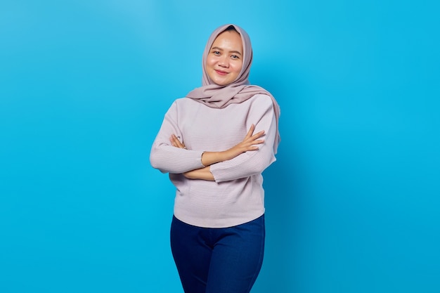 Portrait of smiling young asian woman looking at camera with crossed arms