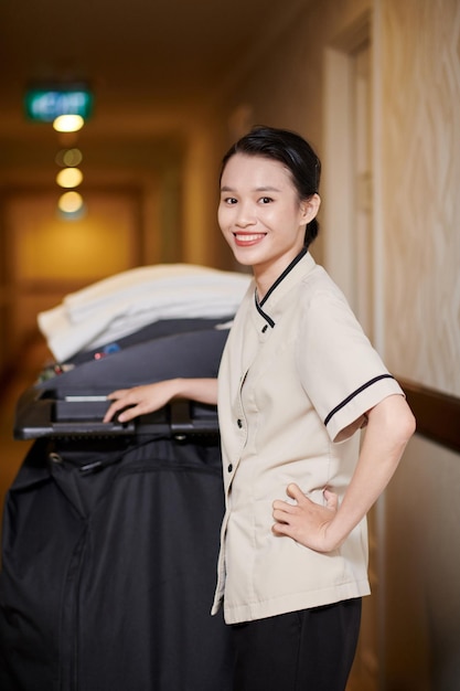 Portrait of smiling young Asian woman working as hotel maid