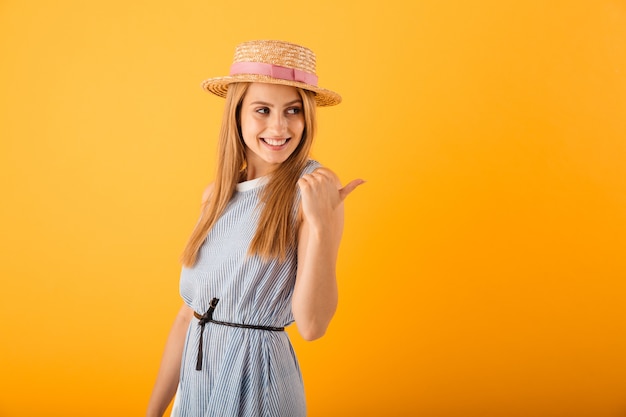 Portrait of a smiling young blonde woman in summer hat