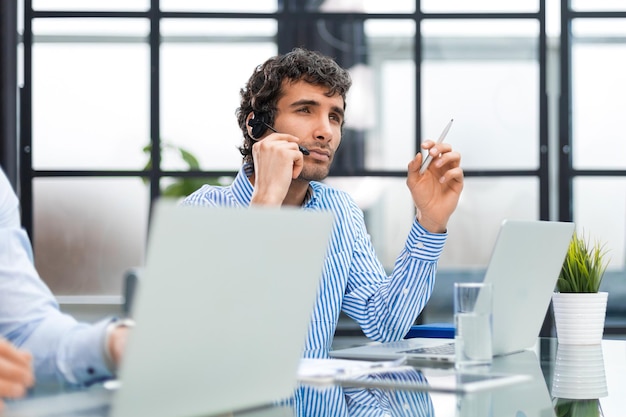 Ritratto di un giovane uomo d'affari sorridente che lavora al computer in ufficio con il suo collega