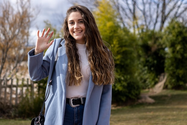 Portrait of a smiling young caucasian woman waving Video call screen