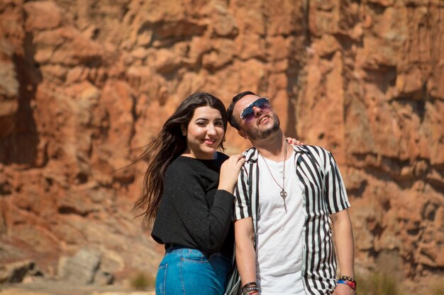 Portrait of smiling young couple standing against mountain