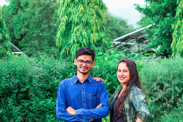 Photo portrait of smiling young couple standing against trees in forest