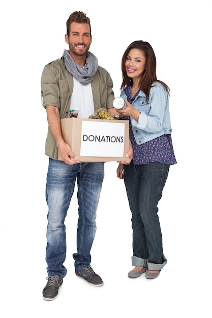 Portrait of a smiling young couple with donation box