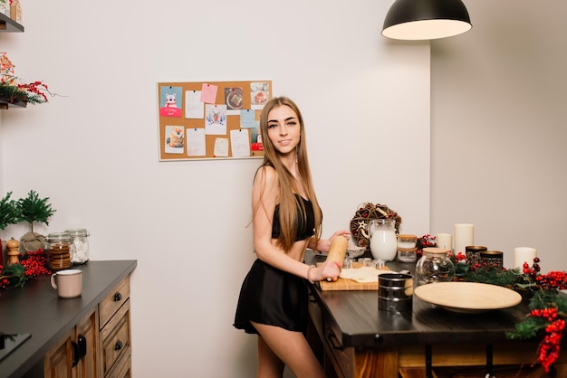Портрет улыбающейся молодой домохозяйки на современной кухне