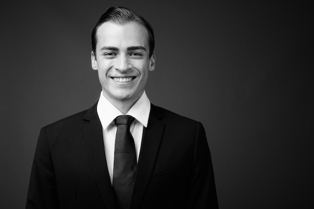 Photo portrait of smiling young man against black background