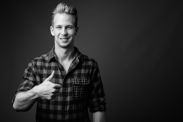 Photo portrait of smiling young man against black background