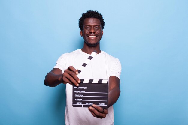 Photo portrait of a smiling young man against blue background