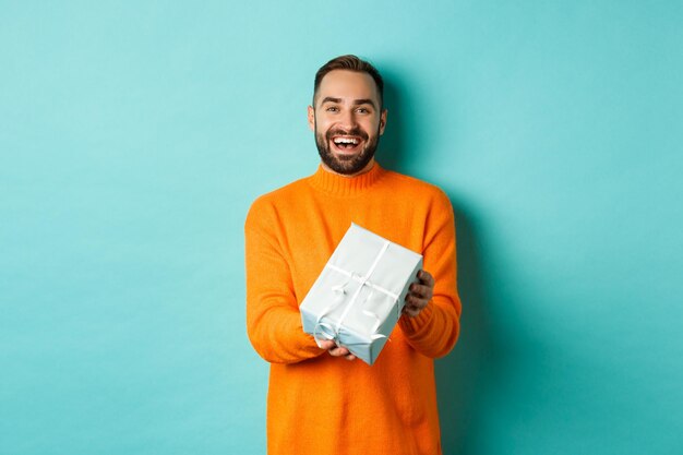 Portrait of a smiling young man against blue background