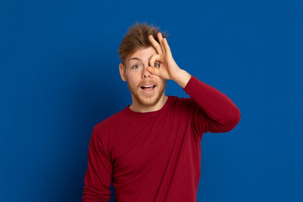 Photo portrait of smiling young man against blue background