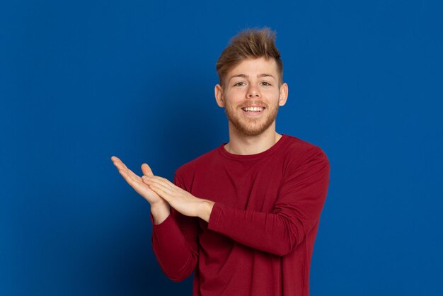 Portrait of smiling young man against blue background