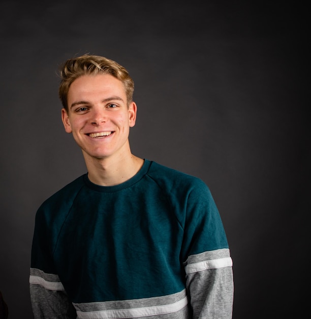 Portrait of smiling young man against gray background