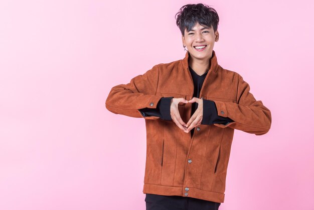 Portrait of smiling young man against pink background