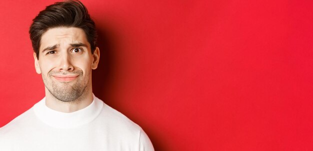 Portrait of smiling young man against red background