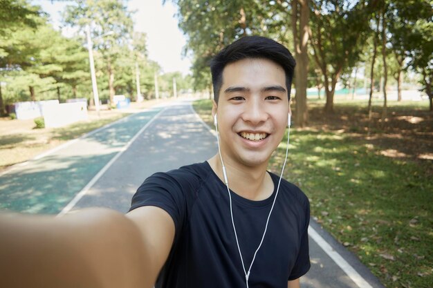 Photo portrait of smiling young man against trees