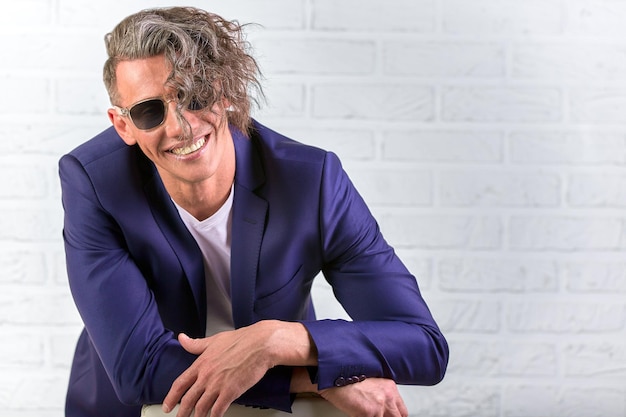 Photo portrait of a smiling young man against wall