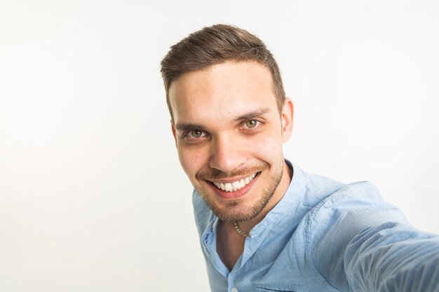 Portrait of smiling young man against white background