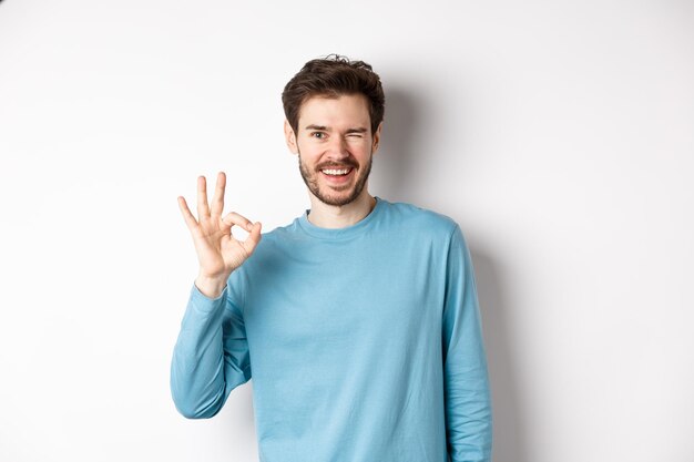 Photo portrait of smiling young man against white background