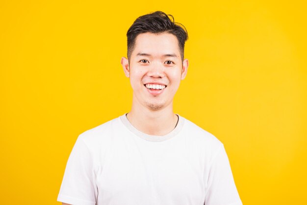 Portrait of smiling young man against yellow background