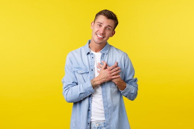 Portrait of a smiling young man against yellow background