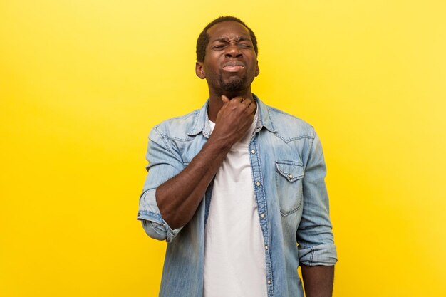 Portrait of a smiling young man against yellow background