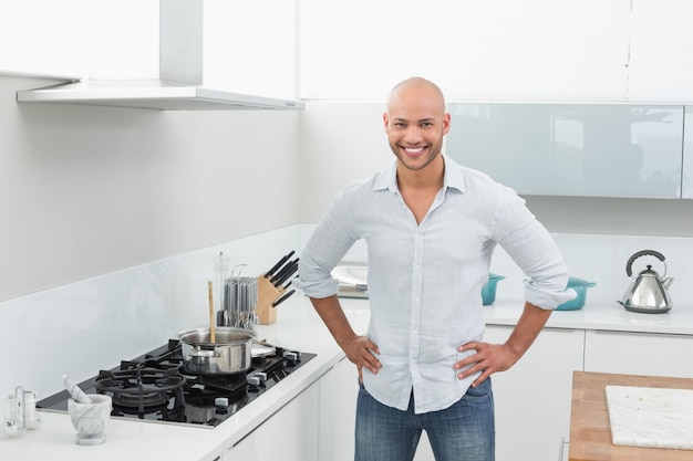 Portrait of smiling young man besides kitchen stove