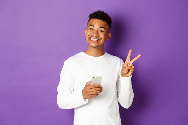 Portrait of a smiling young man holding camera