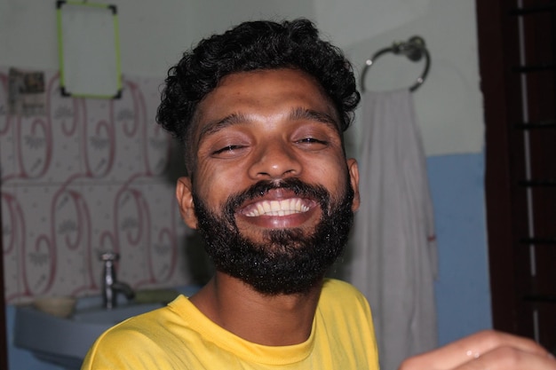 Photo portrait of smiling young man standing against bathroom