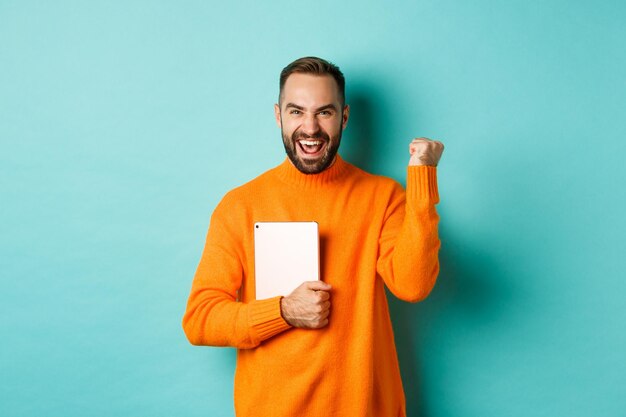 Portrait of smiling young man standing against blue background