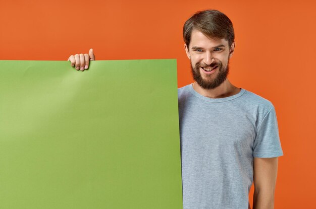 Portrait of smiling young man standing against orange background