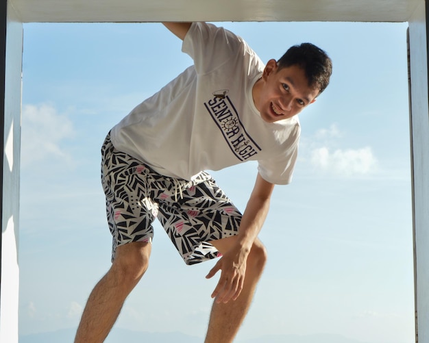 Portrait of smiling young man standing against sky